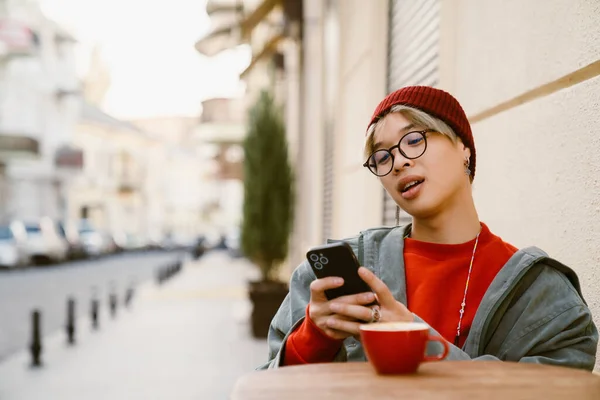 Asiático Menino Usando Telefone Celular Enquanto Bebe Café Café Livre — Fotografia de Stock