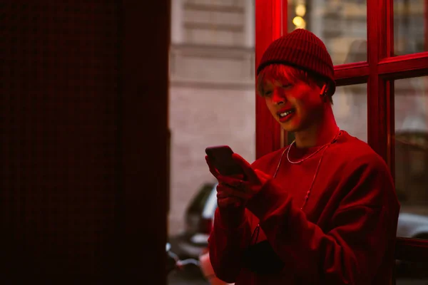 Asiático Chico Usando Teléfono Celular Auriculares Mientras Pie Puerta —  Fotos de Stock