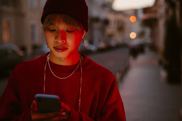 Asijské Chlapec Pomocí Mobilu Sluchátek Zatímco Stojí Ulici — Stock fotografie