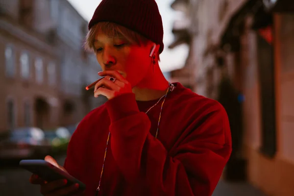 Şehir Caddesinde Sigara Içerken Cep Telefonu Kullanan Kulaklıklı Asyalı Bir — Stok fotoğraf