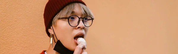 Asiatisk Pojke Bär Glasögon Äta Kaka När Står Vid Väggen — Stockfoto