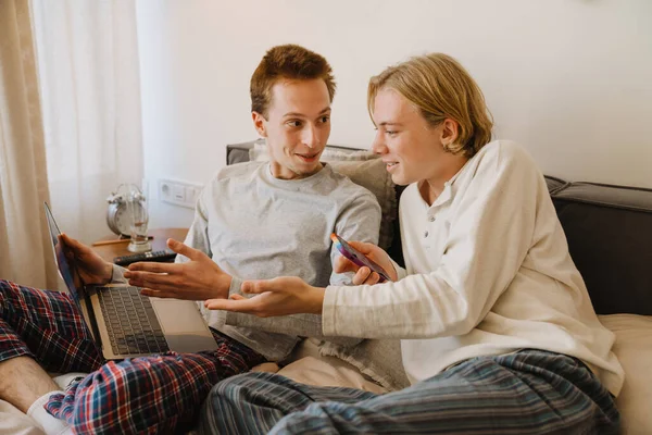 Unga Homosexuella Par Som Använder Mobiltelefon Och Laptop När Vilar — Stockfoto