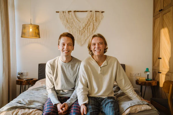 Jong Gay Paar Lachen Kijken Naar Camera Terwijl Zitten Bed — Stockfoto