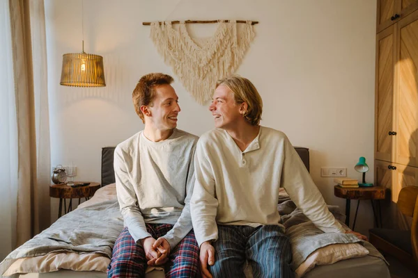 Jong Gay Paar Lachen Kijken Naar Elkaar Terwijl Zitten Bed — Stockfoto