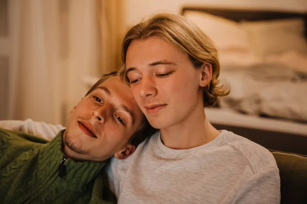 Jovem Gay Casal Abraçando Descansando Sofá Enquanto Assistindo Casa — Fotografia de Stock