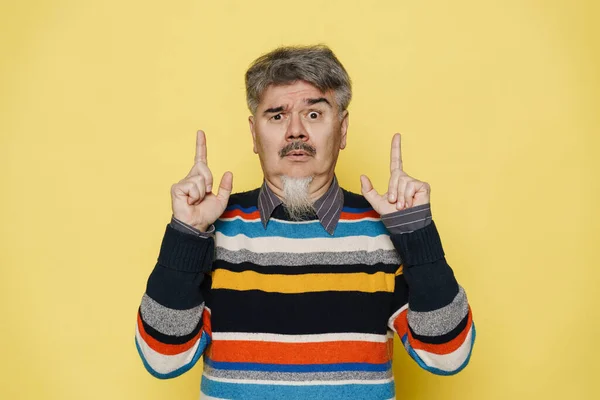 Mature Man Expressing Surprise Pointing Fingers Upward Isolated Yellow Background — Stock Photo, Image