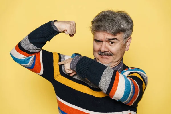Mature Man Showing Pointing Finger His Bicep Isolated Yellow Background — Stock Photo, Image