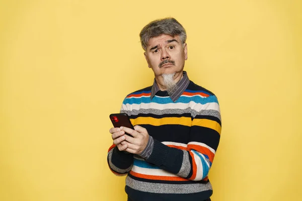 Mature Perplexed Man Grey Beard Using Mobile Phone Isolated Yellow — Stock Photo, Image