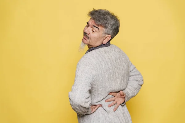 Senior Grey Man Backache Rubbing His Back Isolated Yellow Background — Stock Photo, Image