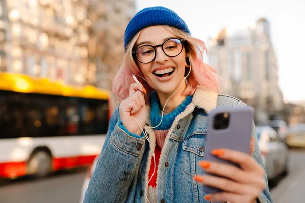 Молода Біла Жінка Навушниках Сміється Використовує Мобільний Телефон Міській Вулиці — стокове фото