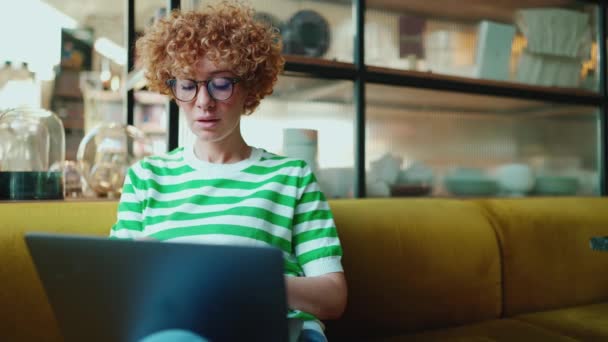 Koncentrerad Rödhårig Kvinna Glasögon Som Arbetar Laptop Kafé Inomhus — Stockvideo