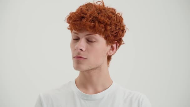 Dalgın Kızıl Saçlı Genç Adam Etrafa Bakıyor Beyaz Stüdyoda Kameraya — Stok video