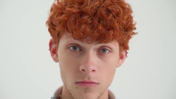 Vicces Vörös Hajú Fiatalember Kijavítja Frizuráját Kamera Előtt Fehér Stúdióban — Stock videók