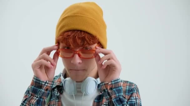 Güneş Gözlüklü Hoş Kızıl Saçlı Adam Beyaz Stüdyodaki Kameraya Bakıyor — Stok video