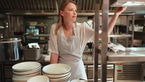 Pozytywna Kobieta Szef Kuchni Patrząc Kolejność Kuchni Restauracji — Wideo stockowe