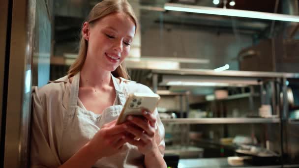Riendo Mujer Rubia Chef Escribiendo Teléfono Inteligente Cocina Del Restaurante — Vídeos de Stock