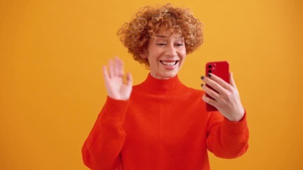 Csinos Göndör Hajú Vörös Hajú Beszél Videohívással Telefonon Üdvözléssel Sárga — Stock videók