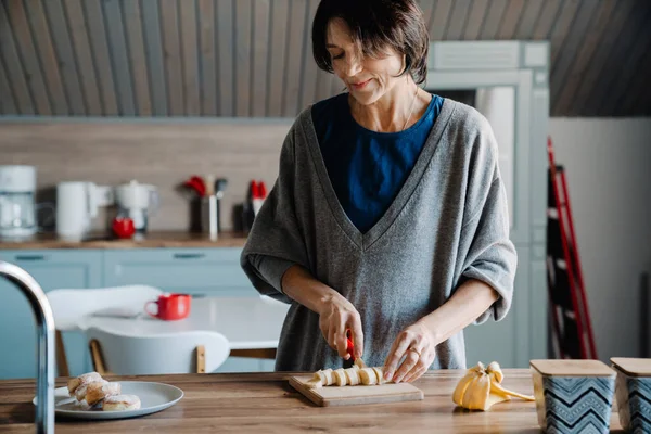 Valkoinen Kypsä Nainen Hymyilee Tehdessään Aamiaista Keittiössä Kotona — kuvapankkivalokuva