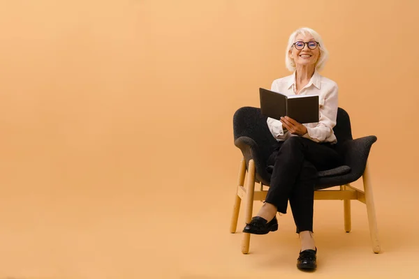 Güzel Gülümseyen Takım Elbiseli Kahverengi Arka Planda Defteriyle Koltukta Oturan — Stok fotoğraf