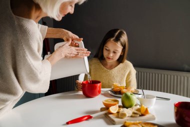 Beyaz, son sınıf öğrencisi, torunuyla evde çay içiyor.