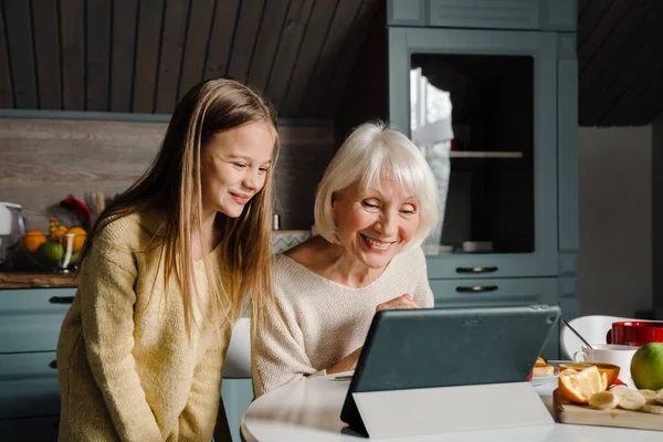 Ηλικιωμένη Γυναίκα Και Εγγονή Της Χρησιμοποιώντας Tablet Υπολογιστή Ενώ Έχοντας — Φωτογραφία Αρχείου