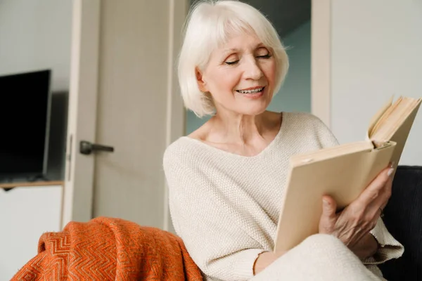 Счастливая Зрелая Женщина Читает Книгу Сидя Дома Диване — стоковое фото