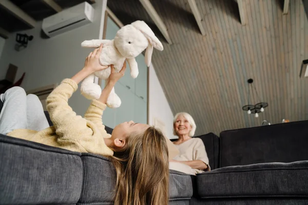 Menina Branca Brincando Com Seu Brinquedo Enquanto Descansa Sofá Casa — Fotografia de Stock