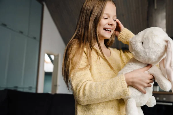 Menina Branca Rindo Enquanto Está Com Seu Coelho Brinquedo Casa — Fotografia de Stock