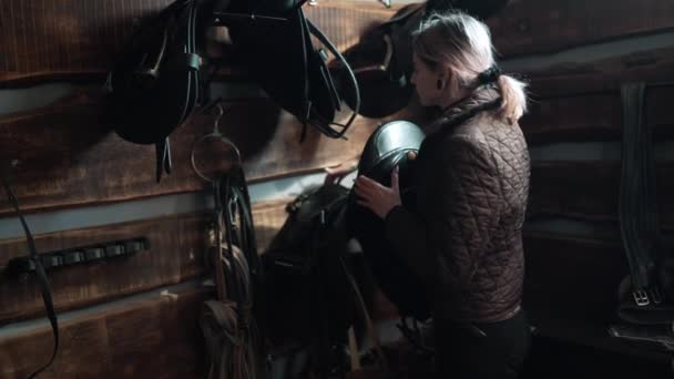 Confident Woman Rider Removes Riding Saddle Wall Stable — Stock Video