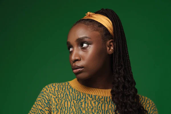 Młoda Czarna Kobieta Afro Warkocze Pozowanie Patrząc Bok Odizolowany Zielonym — Zdjęcie stockowe