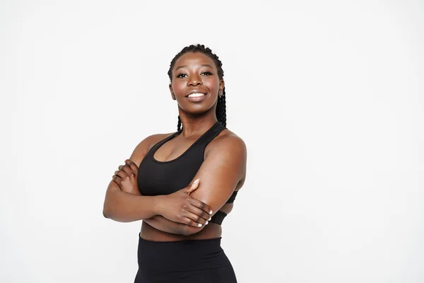 stock image Young black sportswoman with afro pigtails smiling and looking aside isolated over white background