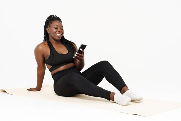 Mujer Joven Negra Usando Celular Durante Práctica Yoga Aislada Sobre — Foto de Stock