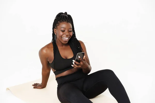 Mujer Joven Negra Usando Celular Durante Práctica Yoga Aislada Sobre — Foto de Stock