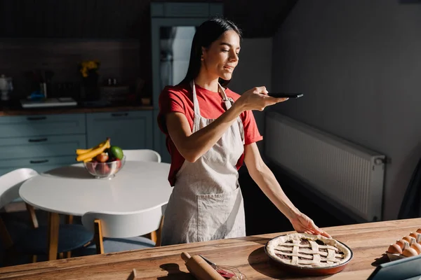 Jovem Hispânica Morena Vestindo Avental Tirando Foto Refeição Enquanto Cozinha — Fotografia de Stock