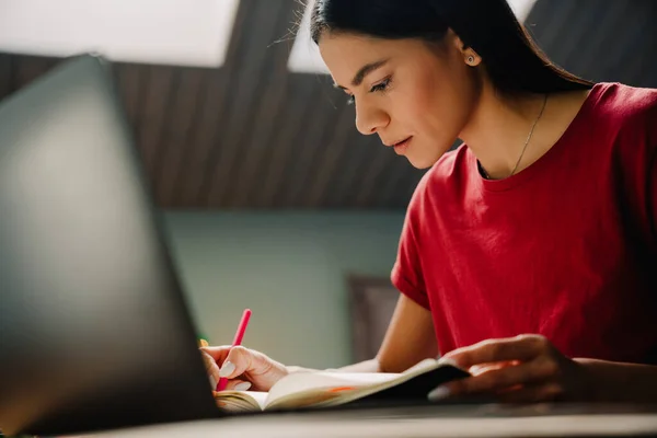 Young Hispanic Woman Writing Notes While Working Laptop Home —  Fotos de Stock