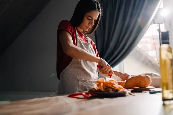 Jovem Hispânica Cortando Batata Doce Enquanto Cozinha Cozinha Casa — Fotografia de Stock