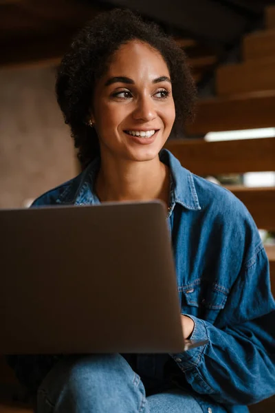 Jovem Mulher Negra Vestindo Camisa Jeans Sorrindo Usando Laptop Casa — Fotografia de Stock