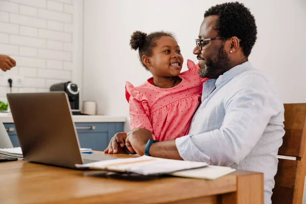 Afroamerikansk Man Kramar Sin Dotter När Han Jobbar Laptop Hemma — Stockfoto