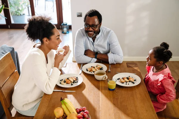Afroamericana Familia Mujer Hombre Con Pequeña Hija Sonriendo Desayunando Casa —  Fotos de Stock