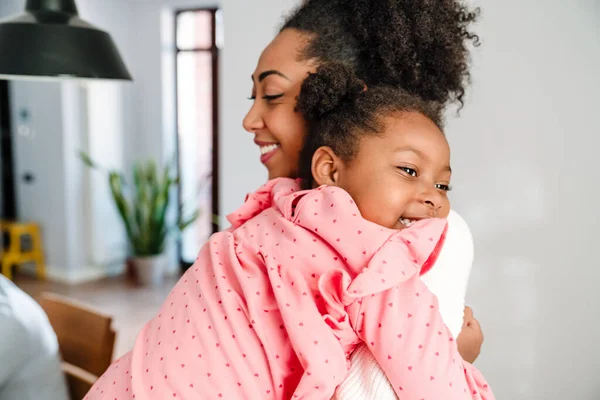 Afroamericana Feliz Mujer Adulta Sonriendo Abrazando Pequeña Hija Casa —  Fotos de Stock