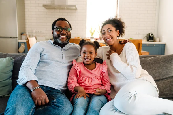 Afroamericana Familia Mujer Hombre Con Pequeña Hija Sonriendo Sentado Sofá — Foto de Stock