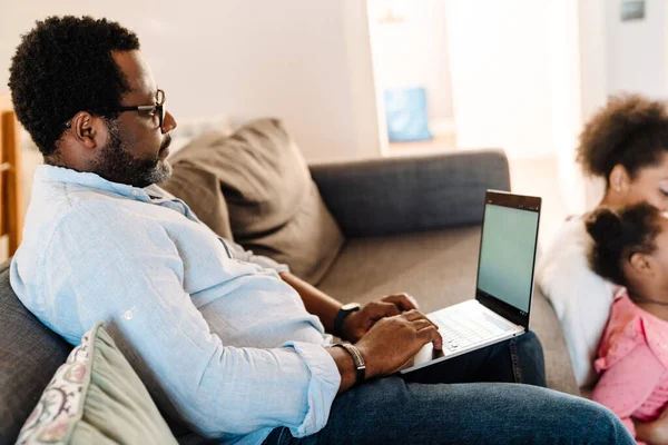 Uomo Afroamericano Che Utilizza Computer Portatile Mentre Seduto Sul Divano — Foto Stock