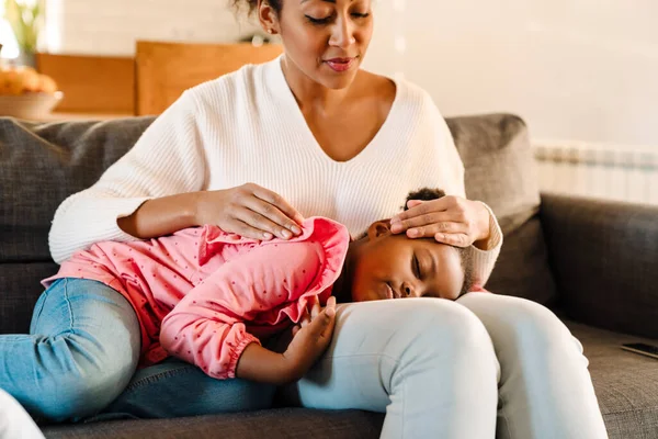 Afroamerikanerin Sitzt Hause Auf Sofa Während Ihre Kleine Tochter Schläft — Stockfoto