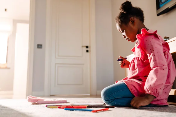 Afro Amerikalı Küçük Kız Yerde Oturuyor Evde Işaretlerle Çizim Yapıyor — Stok fotoğraf