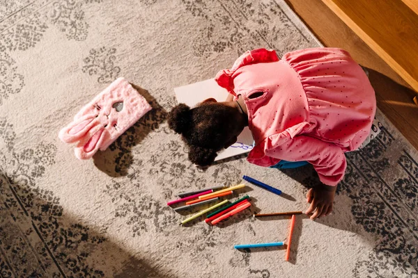 Африканская Маленькая Девочка Сидит Полу Рисует Маркерами Дома — стоковое фото