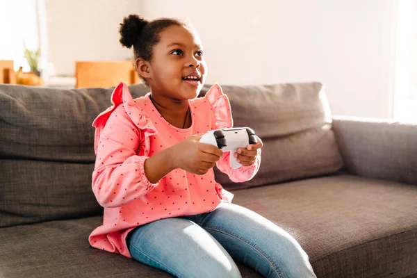 Niña Afroamericana Sentada Sofá Jugando Videojuegos Con Controlador Casa —  Fotos de Stock