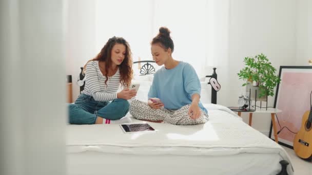 Веселі Подружки Дивляться Телефон Розмовляють Ліжку — стокове відео