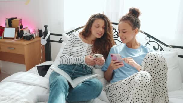 Boldog Barátnők Sms Eznek Telefonon Otthon Beszélgetnek Ágyon — Stock videók