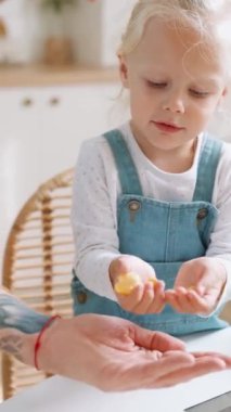 Olumlu kız müsli 'yi babasının avucuna koyar.