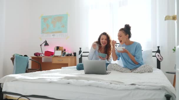Щасливі Подружки Їдять Локшину Дивиться Фільм Ліжку Вдома — стокове відео